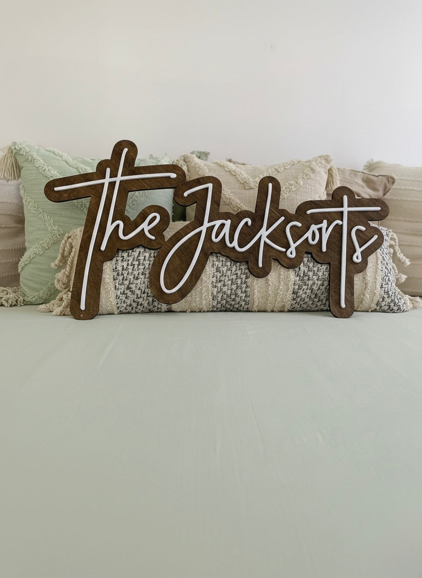 A custom last name wooden sign positioned against bohemian styled pillows.