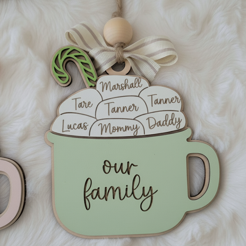 Decorative sign shaped like a mug with family names on a soft white background